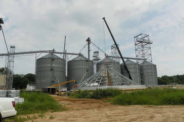 five grain bins a part of a big system under construction in rural area