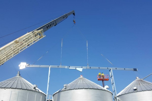 grain bins in a work zone with a crane over them