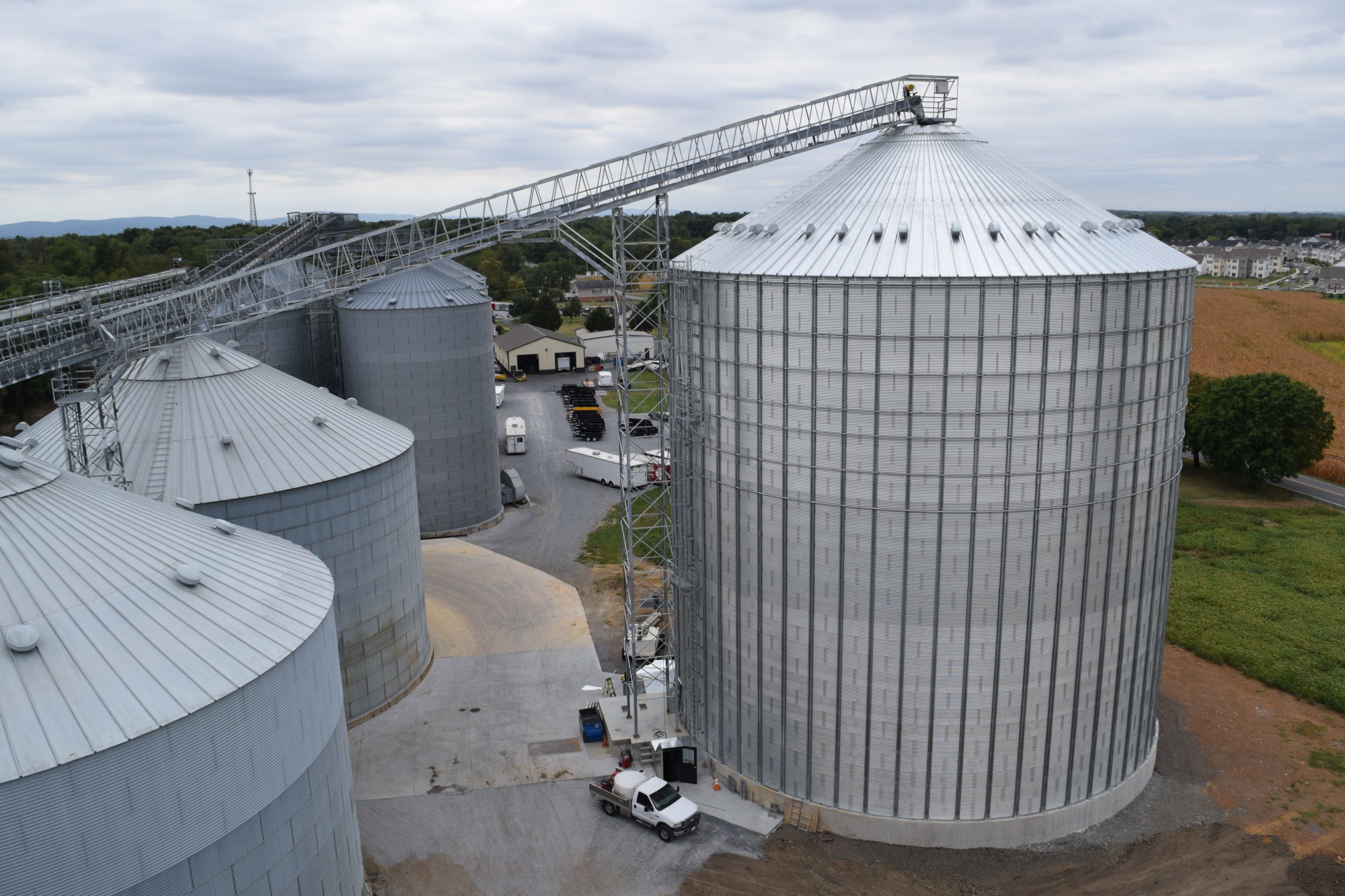 large grain bin next to smaller grain bins on farm